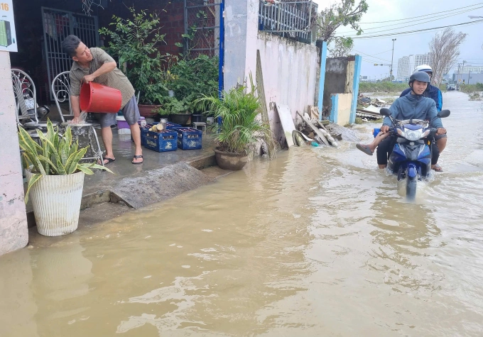 Ông Nguyễn Thanh Tuấn, dọn dẹp nhà cửa sau khi nước rút bớt. Ảnh: Trần Hóa